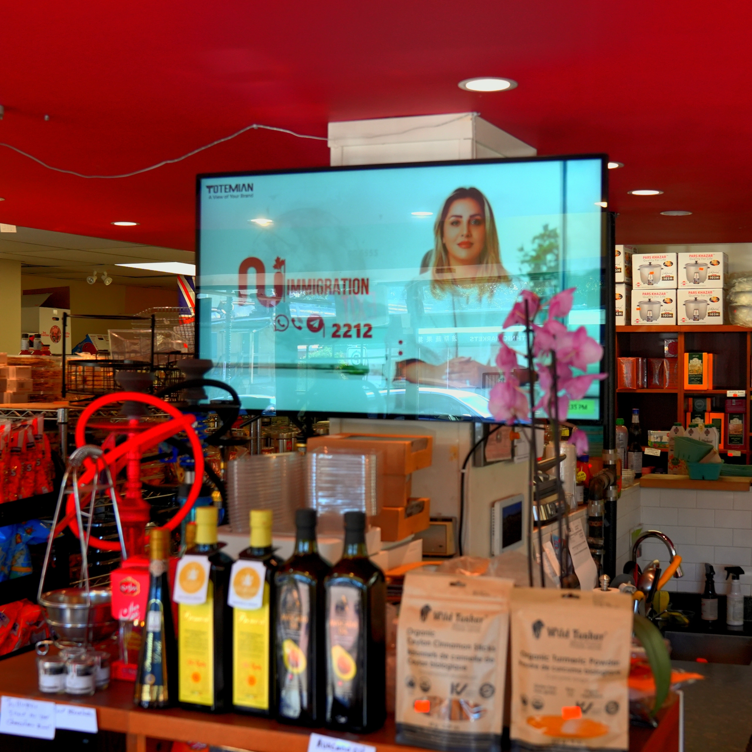 A large, bright digital brandboard display advertising an immigration agency.